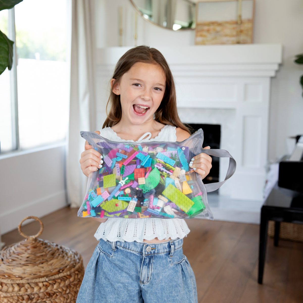 Child holding a mesh pouch full of building blocks